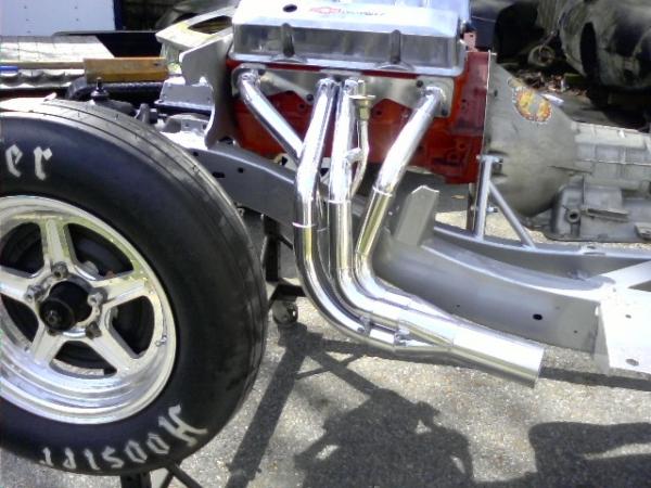 Left side header detail showing a modified front tube for steering column clearence.  Mahaffey collector core pan evacuation system and Nitroplate finish.  Each primary tube has it's own bung welded in place for exhaust temperature probes